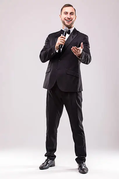 Young Showman presenter with microphone against white background.Showman concept.