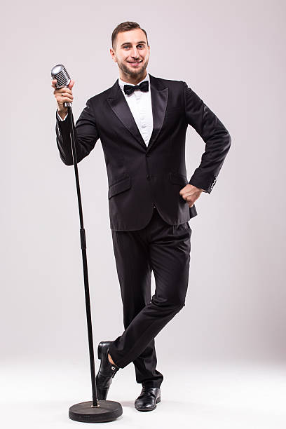 istock Young man in suit singing over the microphone with energy. 628998318