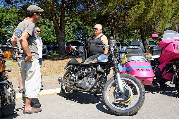 motorcycle enthusiasts group around an old triumph triton Bagard, France - July 9, 2016: motorcycle enthusiasts group around an old triumph triton is a rare and sought after model. norton brand name stock pictures, royalty-free photos & images