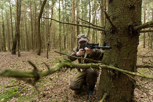 istock soldiers in the coniferous forest with a gun 629010408