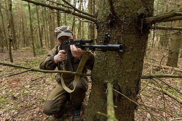 istock soldiers in the coniferous forest with a gun 629010474