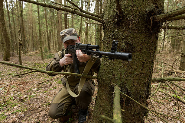 istock soldiers in the coniferous forest with a gun 629010498