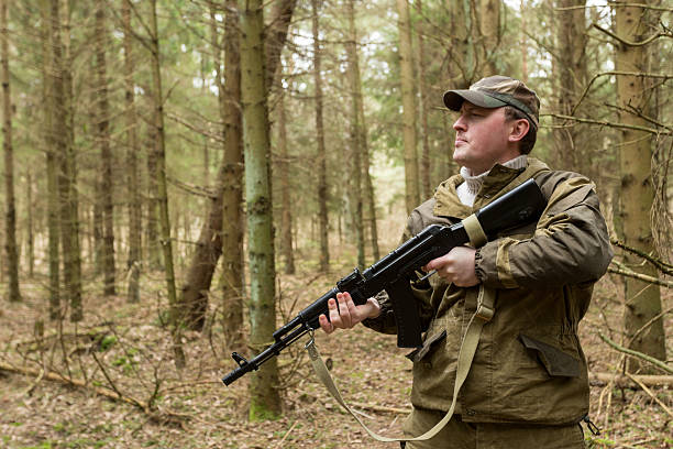 istock soldiers in the coniferous forest with a gun 629010618