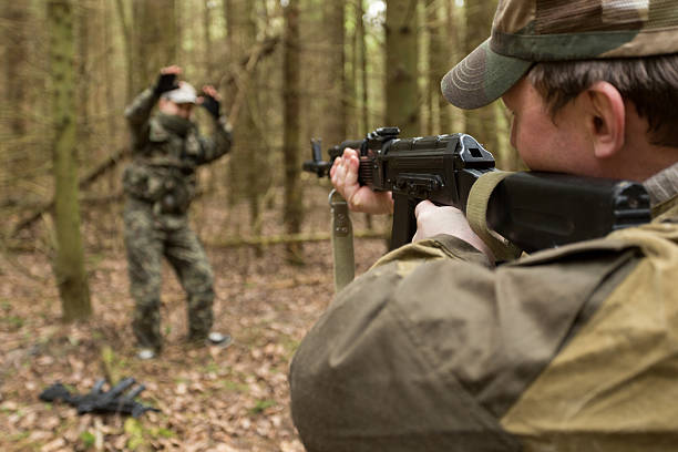 istock soldiers in the coniferous forest with a gun 629010786