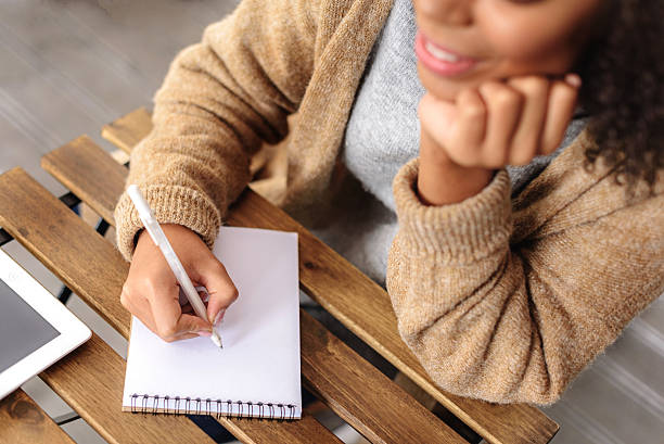 chica creativa tomando notas en el bloc de notas - generic currency fotografías e imágenes de stock