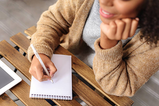 creative girl taking a notes in the notepad hand of a woman drawing in a jotter on the table, selective focus teen wishing stock pictures, royalty-free photos & images