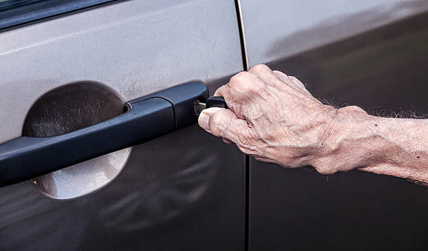 elderly 90 year old man's hand unlocking car driver door - 80 year old imagens e fotografias de stock