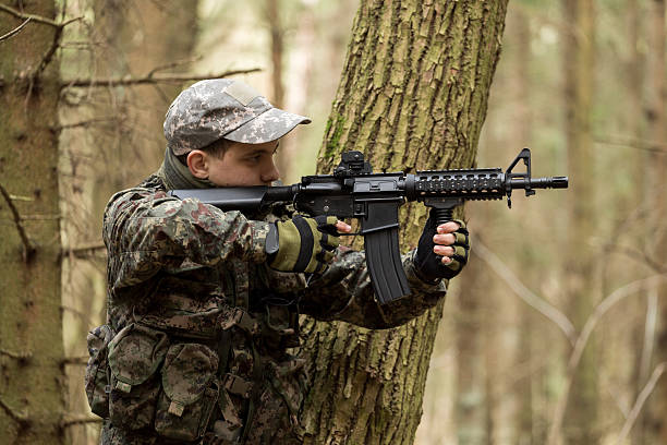 istock soldiers in the coniferous forest with a gun 629011536