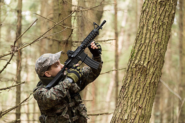 istock soldiers in the coniferous forest with a gun 629011588