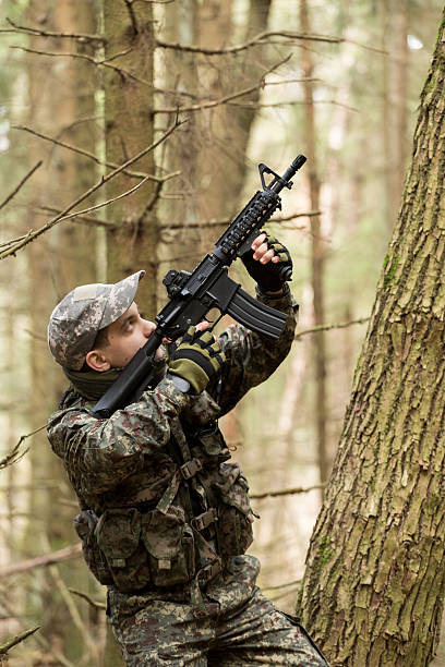 istock soldiers in the coniferous forest with a gun 629011618