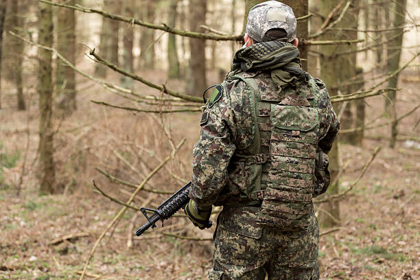 istock soldiers in the coniferous forest with a gun 629011744