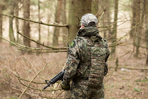 istock soldiers in the coniferous forest with a gun 629011760