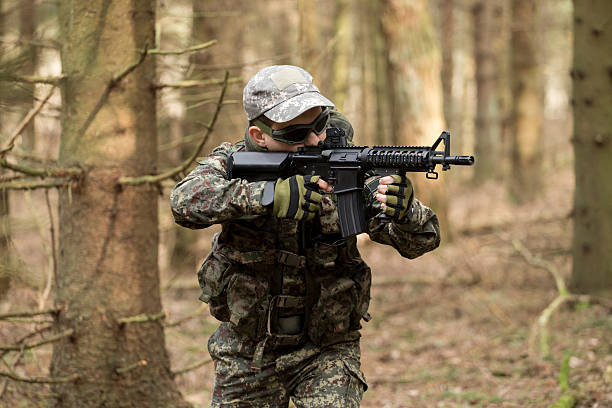 istock soldiers in the coniferous forest with a gun 629012028