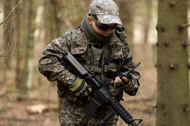 istock soldiers in the coniferous forest with a gun 629012400