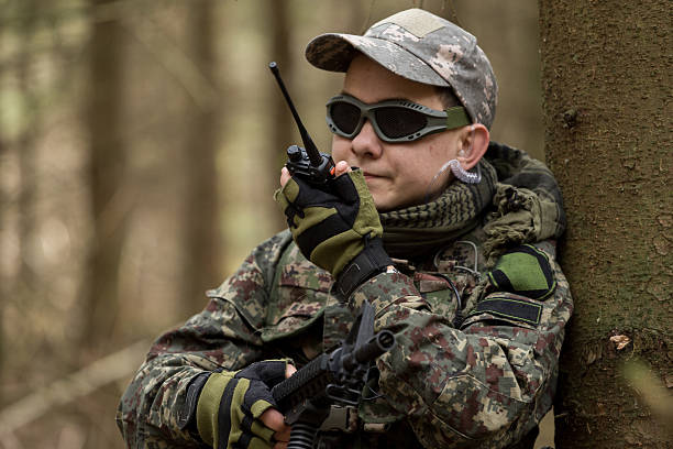 soldiers in the coniferous forest with a gun - airsoft gun imagens e fotografias de stock