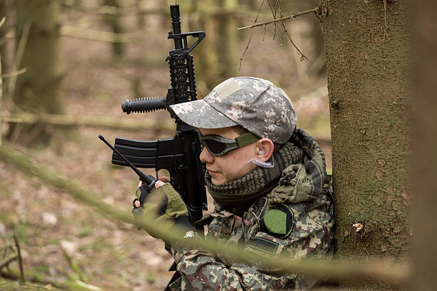 istock soldiers in the coniferous forest with a gun 629012492