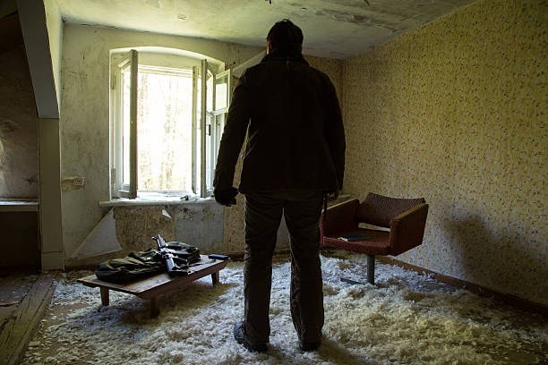 istock man with a gun in the Abandoned destroyed house 629019098