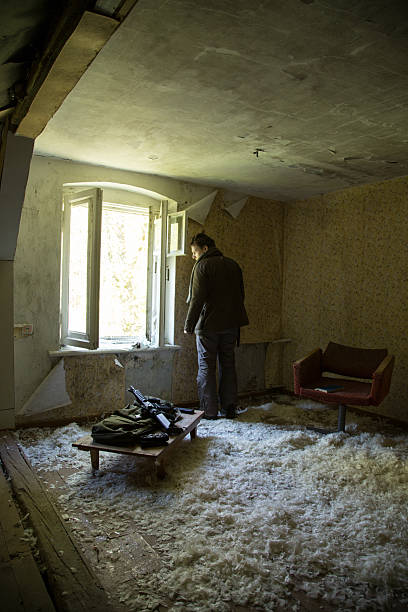 istock man with a gun in the Abandoned destroyed house 629019278