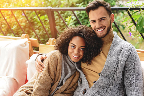 istock cheerful couple smiling while sitting on the couch 629019450