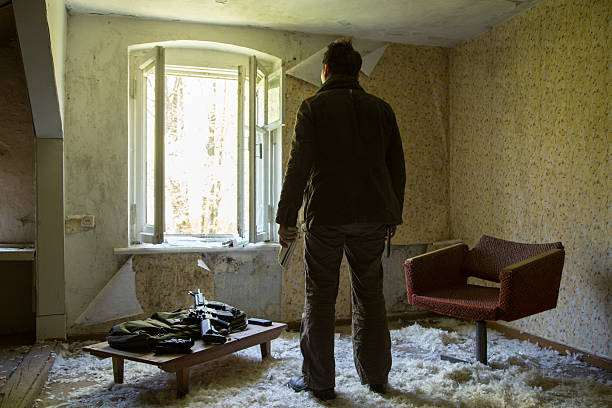 istock man with a gun in the Abandoned destroyed house 629019538
