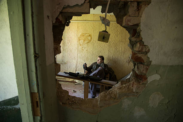 istock man with a gun in the Abandoned destroyed house 629019680