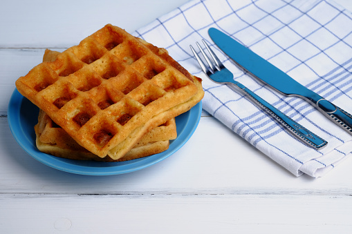 Close up of waffle on blue plante on white wood table background, decoration style, selective focus.