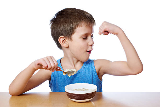 テーブルでおかゆを食べる幸せな男の子孤立 - muscular build food healthy eating human muscle ストックフォトと画像