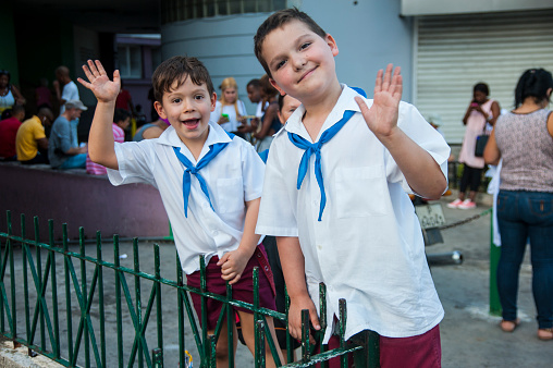Havana, Cuba - November 11, 2016: Two school boys in their school uniforms wave at camera.
