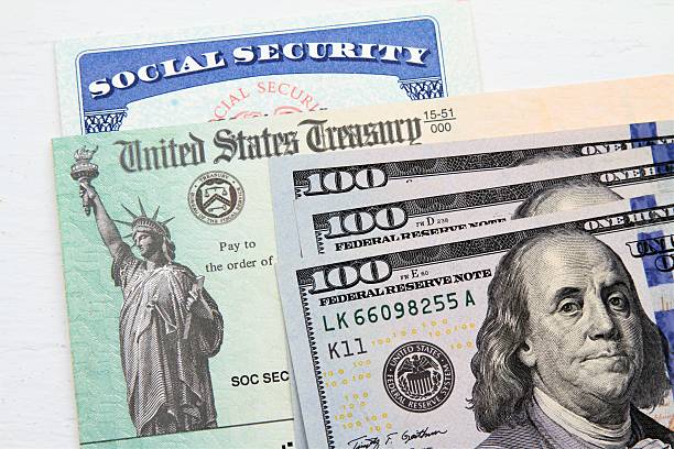 Social Security card, Treasury checks and hundred dollar bills stock photo