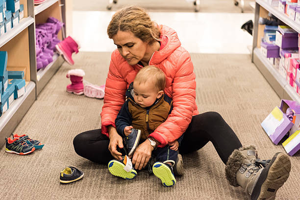Mature woman shopping for shoes for her baby boy