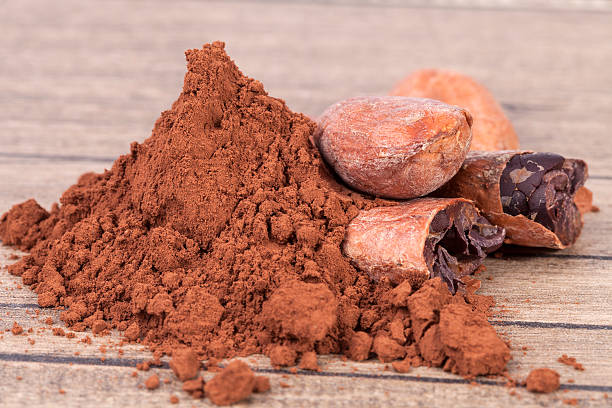 istock Cocoa beans and powder on wooden plank 629048830