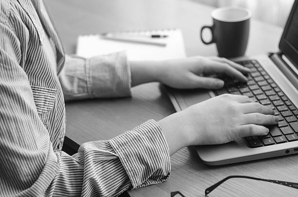 istock Female hands working at a laptop, black and white image 629050502