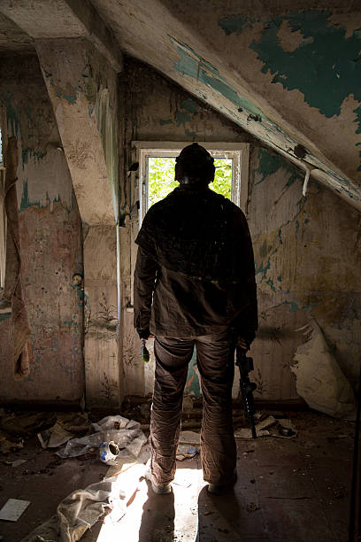 istock man with a gun in the Abandoned destroyed house 629052872