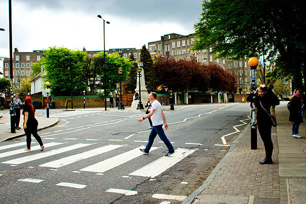 Abbey Road Studios crossing London, UK - May 2, 2016: Abbey Road Studio. These are the famous Abbey Road recording studios road crossing which is near the crossing that the Beatles used on the cover of the Abbey Road album. There are tourist photographing each other trying to replicate the cover for themselves. beatles stock pictures, royalty-free photos & images