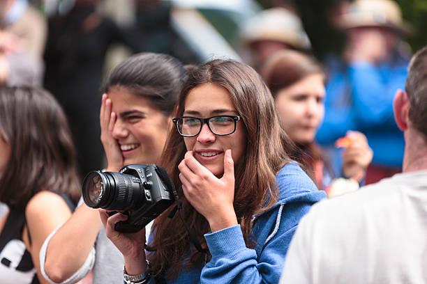 Young woman with camera at open air community event stock photo