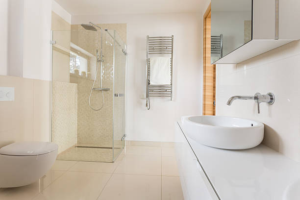 Modern bathroom with glass shower Modern spacious bathroom with bright tiles with glass shower, toilet and sink toilet photos stock pictures, royalty-free photos & images