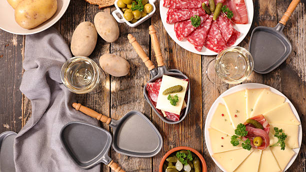 стол с сыром раклетт, мясом и картофелем - raclette cheese стоковые фото и изображения