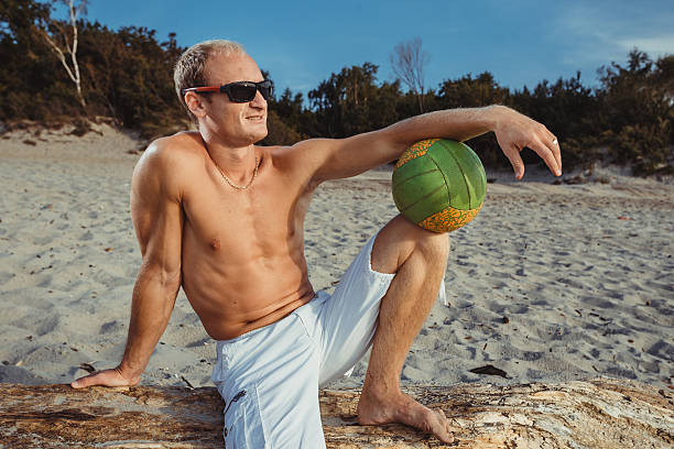 slender man in shorts on a beach - men refreshment male summer imagens e fotografias de stock