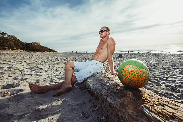 hombre delgado en pantalones cortos en una playa - men refreshment male summer fotografías e imágenes de stock