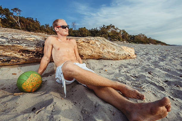 slender man in shorts on a beach - men refreshment male summer imagens e fotografias de stock