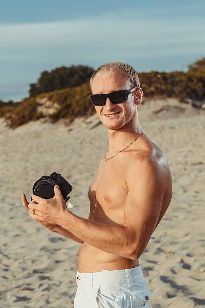 slender man in shorts on a beach - men refreshment male summer imagens e fotografias de stock