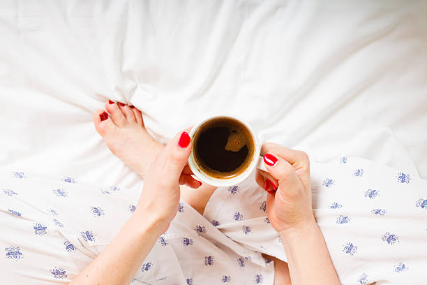 istock woman on bed with cup of coffee 629076198