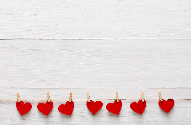 Valentine day background, paper hearts border on wood, copy space Valentine background with red paper hearts row border on clothespins on white rustic wood planks. Happy lovers day card mockup, copy space clothespin photos stock pictures, royalty-free photos & images