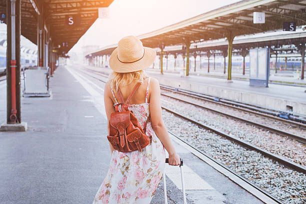 travel by train summer travel, woman with suitcase waiting for  her train on platform of railway station railroad station platform photos stock pictures, royalty-free photos & images