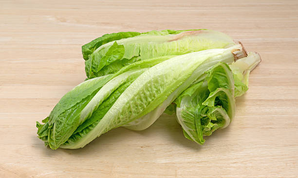 istock Romaine lettuce heads on wood cutting board 629077456