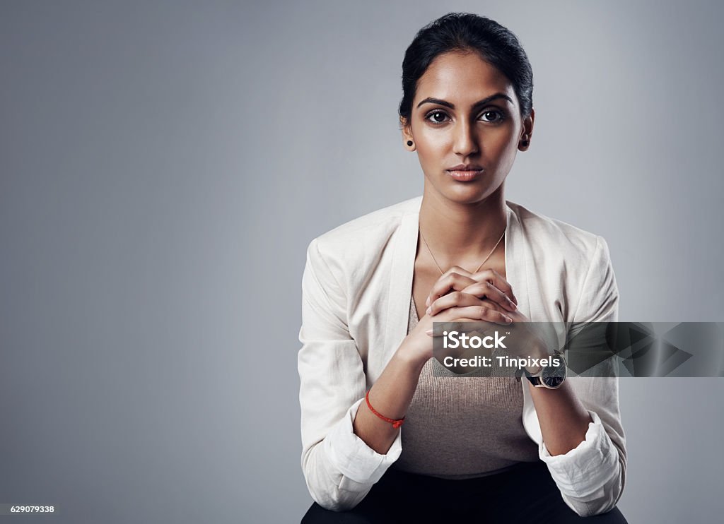 Ready to get to work Studio portrait of a young businesswoman posing against a gray background Women Stock Photo