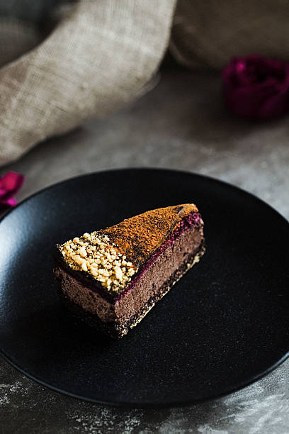 istock Dark chocolate cake cut with rose on  black plate 629079468
