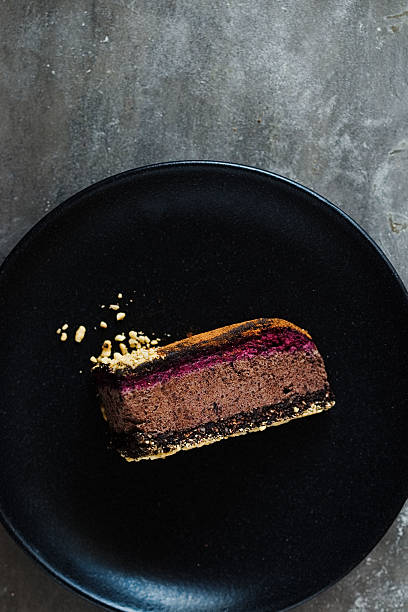 istock Dark chocolate cake cut with rose on  black plate 629079484