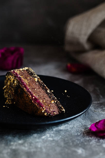istock Dark chocolate cake cut with rose on  black plate 629079506