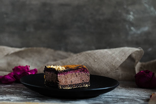istock Dark chocolate cake cut with rose on black plate 629079578